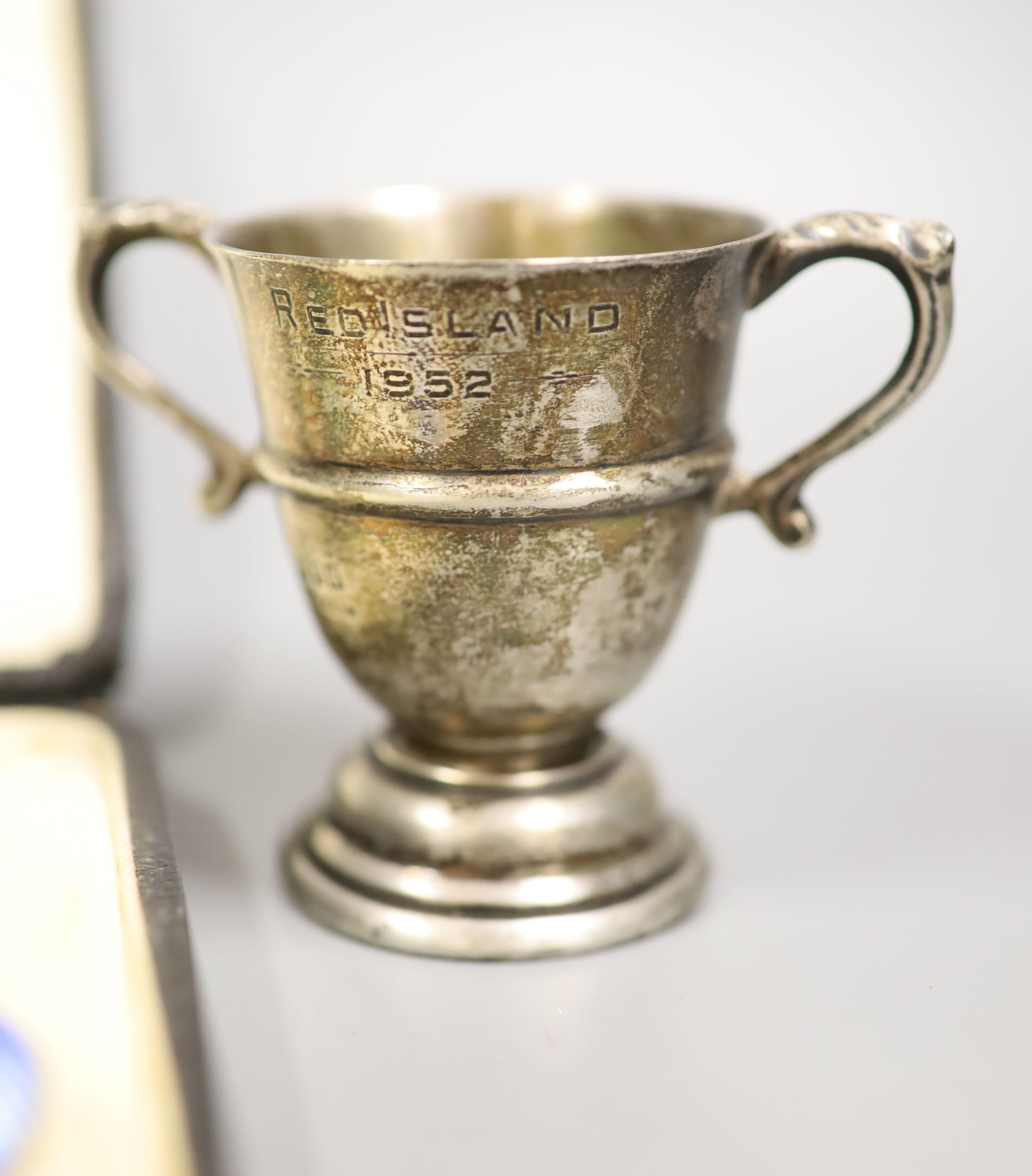 A cased set of six silver and enamel(a.f.) bean end coffee spoons, one other silver spoon, a silver napkin ring and small silver trophy cup.